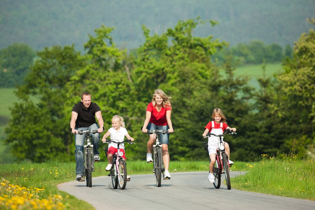 Familie beim Radfahren an einem sommerlichen Tag